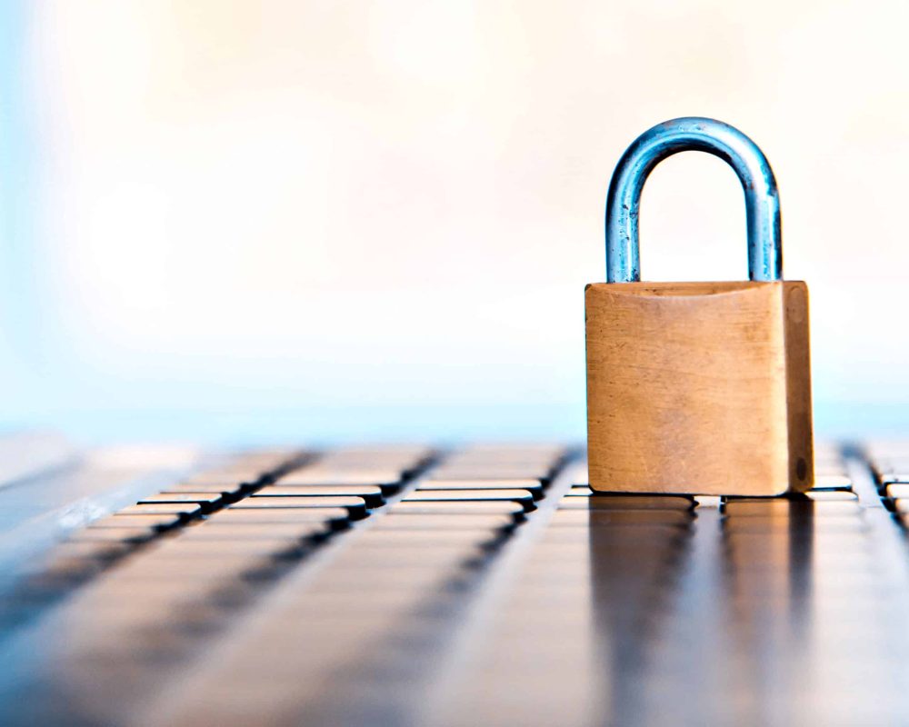 Selective focus on metal lock on keyboard password internet online data privacy information protection security concept.